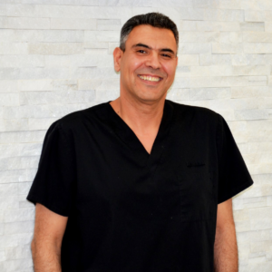 A man in black shirt smiling for the camera.