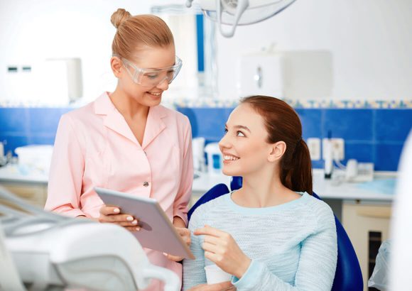 A woman is talking to another person in the dentist 's chair.